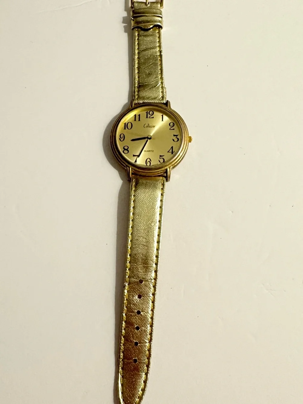 Collezio brand analog wristwatch with a gold dial and synthetic leather strap